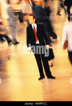 Businessman in crowd, blurred motion Stock Photo