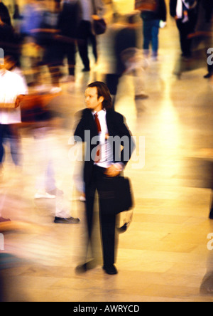 Businessman in crowd, blurred motion Stock Photo