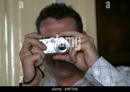 Man taking a picture with a digital compact camera Stock Photo