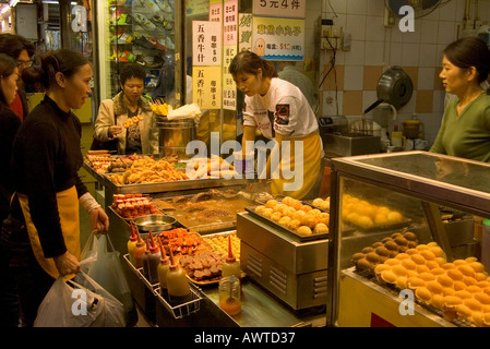 dh  MONG KOK HONG KONG Customers at snack fast food stall street vendor mongkok takeaway meals chinese fastfood people Stock Photo