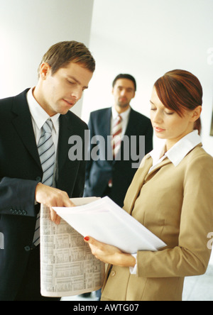 Businesspeople, two in foreground looking at document Stock Photo
