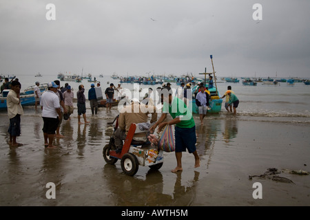 Fishing Harbour Fishing People in Puerto Lopez, Ecuador,Fishing boats returning with loads of fish, Blue boat crowd fishermen Stock Photo