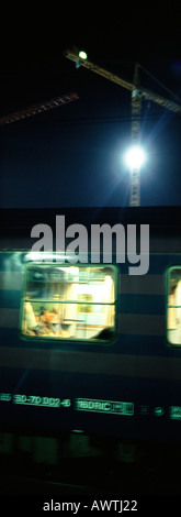 Subway train at night, crane and flood light in background, blurred Stock Photo