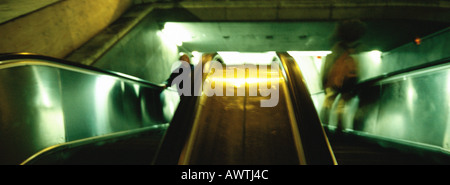 People riding up escalators Stock Photo