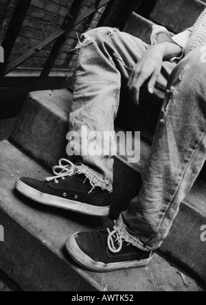 Person sitting on stairs, low section, b&w Stock Photo