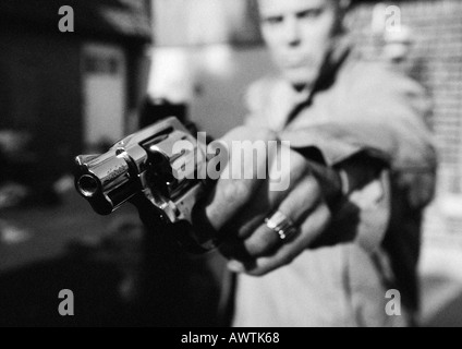 Man holding gun, close-up, b&w Stock Photo