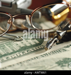 Glasses, keys, cell phone lying on U.S. money Stock Photo