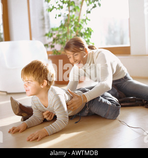 Mother grasping son, on floor Stock Photo
