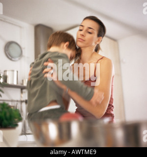 Mother picking up son, waist up, blurred motion Stock Photo