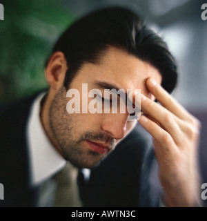 Businessman touching forehead with fingers, portrait Stock Photo
