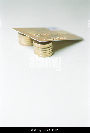 Credit card lying on stacked coins Stock Photo