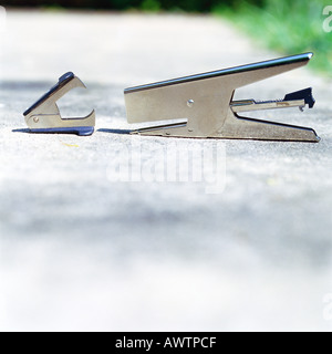 Stapler, staple remover on sidewalk Stock Photo