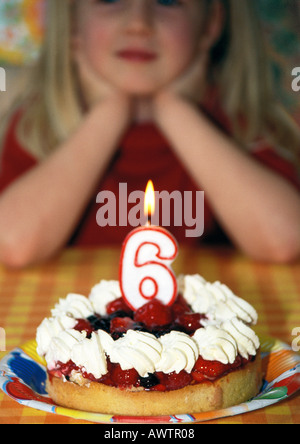 Little girl with birthday cake and candle, focus on foreground Stock Photo