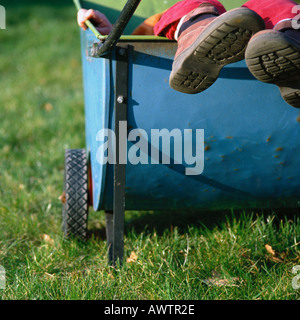 Child's feet sticking out of cart Stock Photo