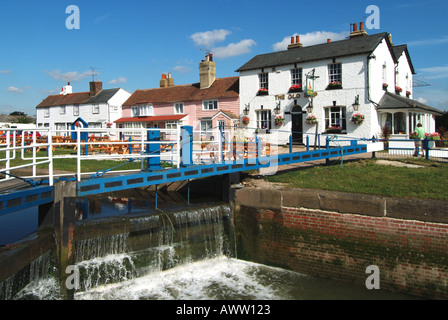 Old Ship Inn Heybridge Basin River Blackwater water spewing over lock gates at junction with tidal estuary The Old Ship inn beyond Essex England UK Stock Photo