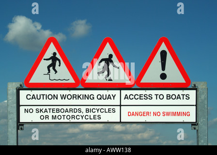 Gantry signs over waterside working quay warning of hazards Stock Photo