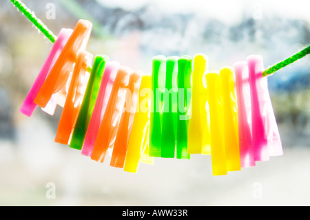 Clothes pegs on string against bright sunlight Stock Photo