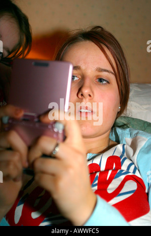 Young girl absorbed in playing hand held video game Stock Photo