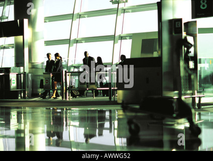 Business people walking through airport terminal gate in the distance. Stock Photo