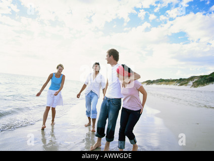 Two couples walking on beach Stock Photo