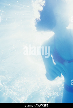 Woman underwater, backlit, low angle view Stock Photo