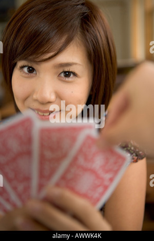 Portrait of young woman with fanned out cards Stock Photo