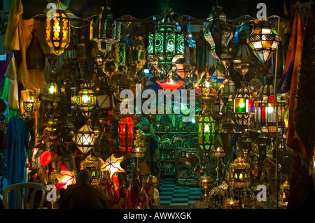 Horizontal close up of a colourful shop selling a myriad of traditional Moroccan lights and lanterns at night.
