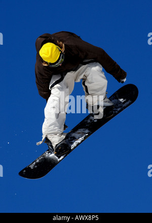 snowboarder springing against blue sky Stock Photo