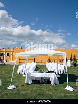 Empty white seats in a field at an outdoor wedding in the sun Stock Photo