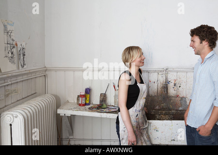 Two college students chatting by sink in art studio Stock Photo