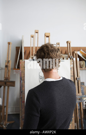 Artist drawing charcoal portrait in studio, back view Stock Photo