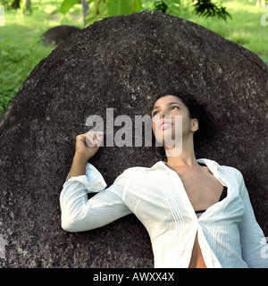 young woman relaxing on a rock in the jungle Stock Photo