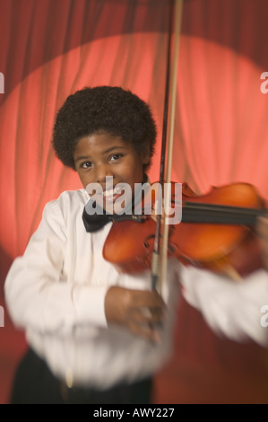 Boy on stage playing the violin Stock Photo