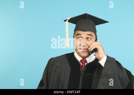 Graduate talking on a mobile phone Stock Photo