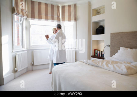 Middle-aged couple dancing in bedroom Stock Photo