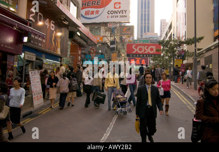 dh  CAUSEWAY BAY HONG KONG Crowded streets people walking down middle of road crowd busy street china Stock Photo