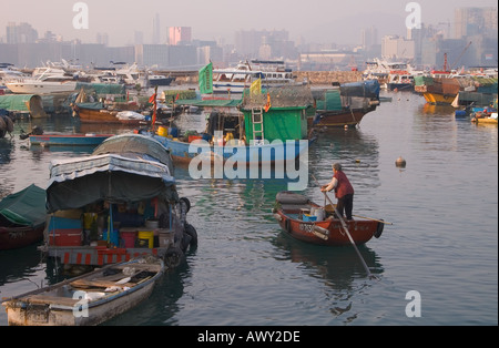 dh Typhoon shelter CAUSEWAY BAY HONG KONG Old woman rowing sampan ferry boat amongst boats harbour boat people Stock Photo