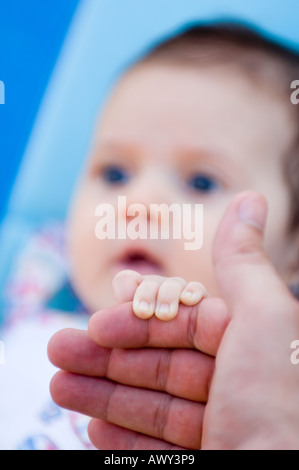 6 months old baby girl holding hand Stock Photo