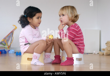 Two toddler girls using a potty Stock Photo