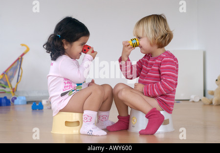 Two toddler girls using a potty Stock Photo