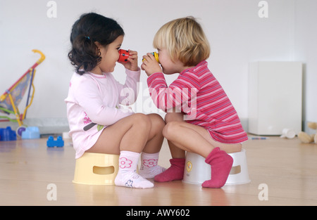 Two toddler girls using a potty Stock Photo