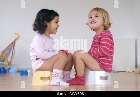 Two toddler girls using a potty Stock Photo