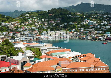 Boats moored in the blue inland harbour of St George's surrounded by colourful buildings, Grenada Stock Photo