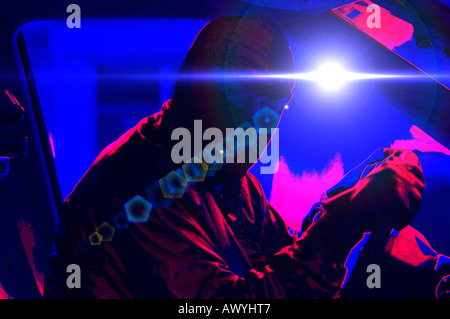 male robber wearing ski mask sitting in car in bank parking lot at night Stock Photo