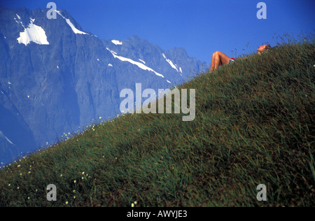 Young woman taking a nap halfway up Mt Sahale North Cascades National Park Washington State USA MR Stock Photo