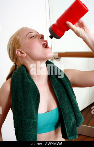 Young woman drinking water during an exercise session Stock Photo