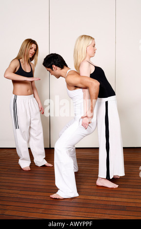 Partners practicing flexibility in yoga and Capoeira programs Stock Photo