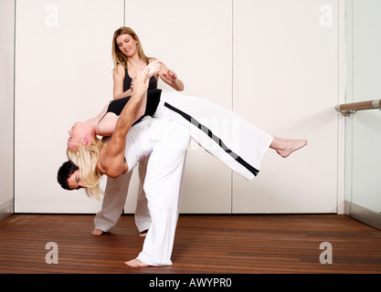 Partners practicing flexibility in yoga and Capoeira programs Stock Photo