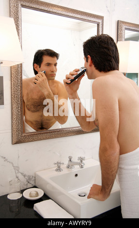 Man shaving in the bathroom mirror Stock Photo