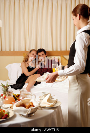 Couple having room service breakfast in hotel room Stock Photo